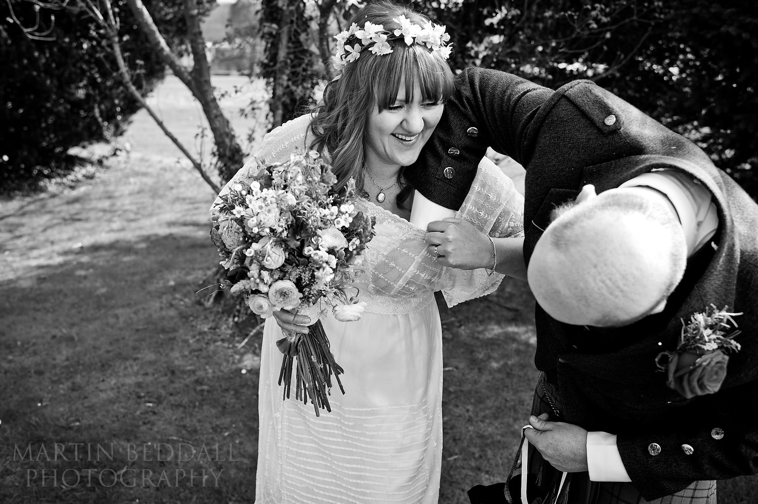 Groom getting confetti out of the bride's dress