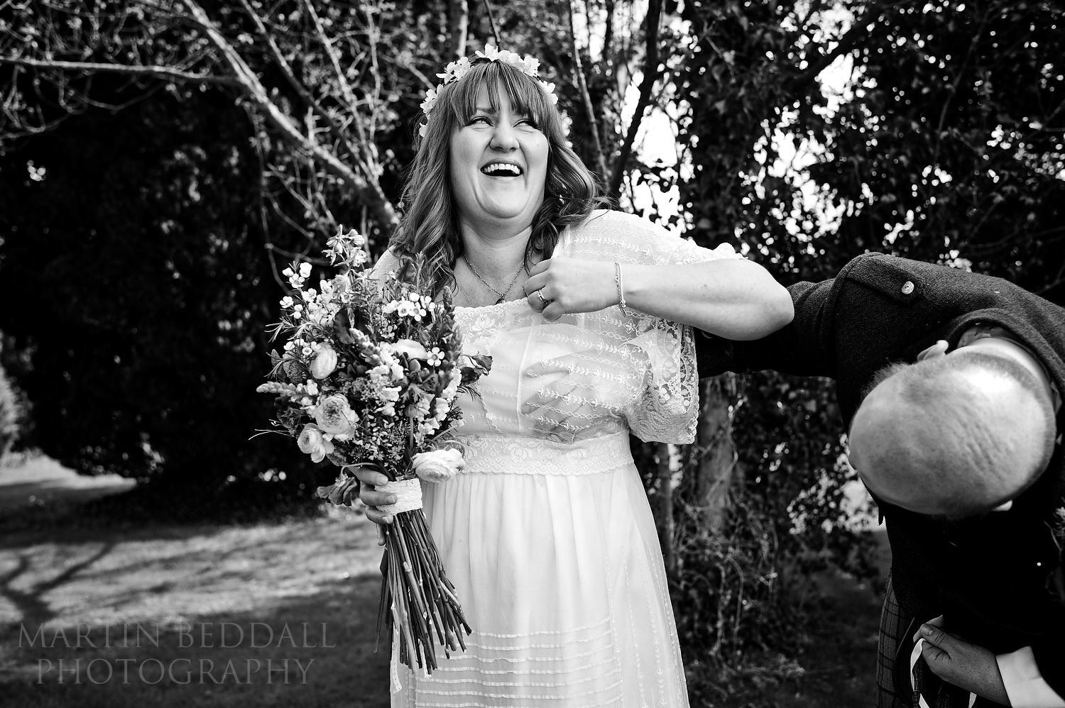 Groom helping get confetti out of the bride's dress