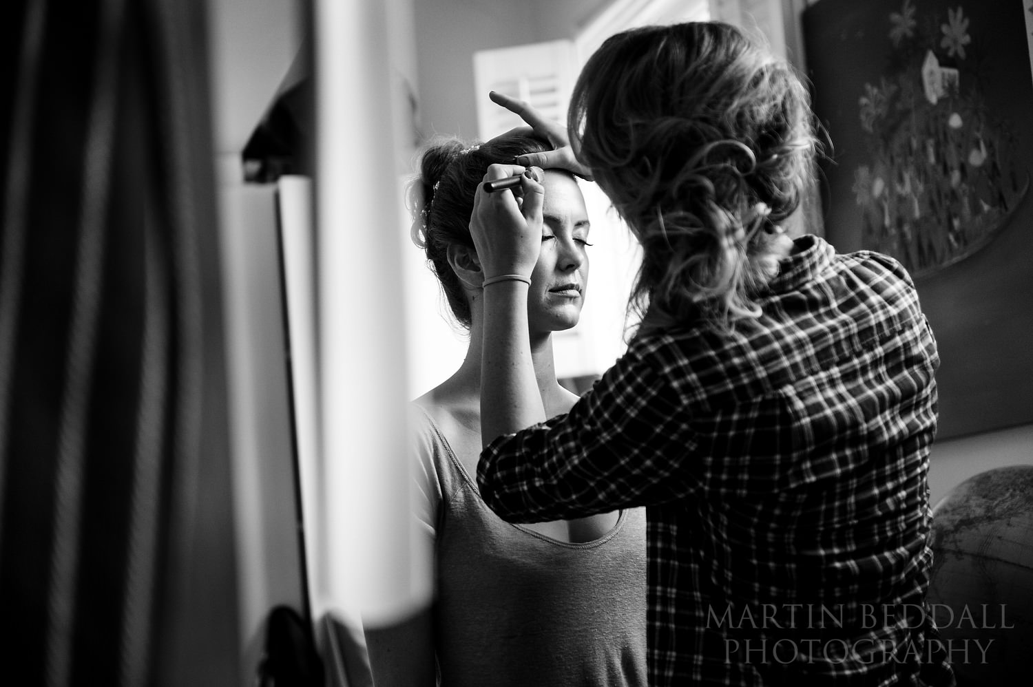 Bride's sister applies her makeup for her