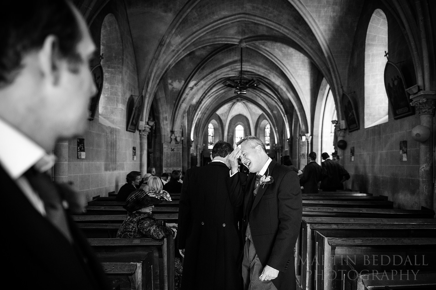 English groom wipes his brow in the church on a hot summers day in France