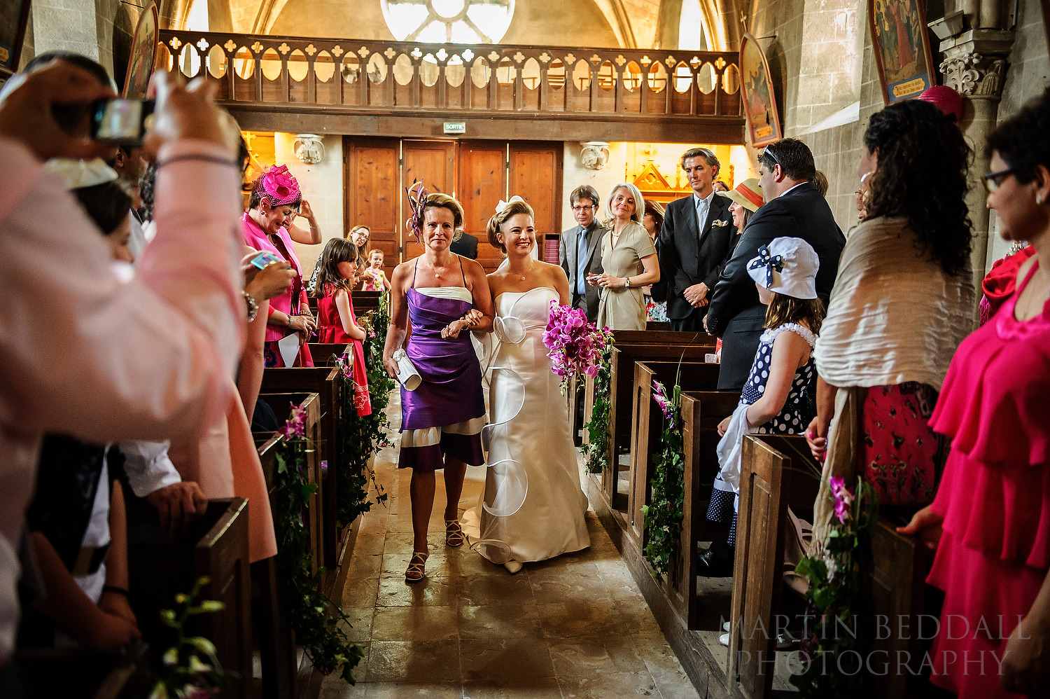 Bride walks down the aisle with her mother at Anglo-French wedding
