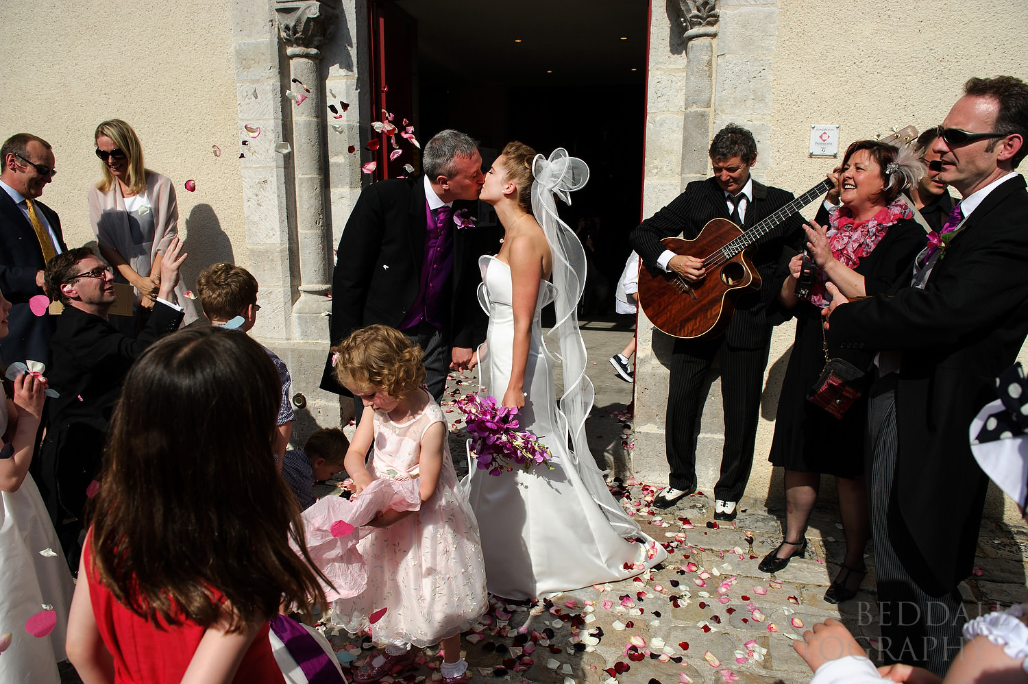 Bride and groom kiss outside the church