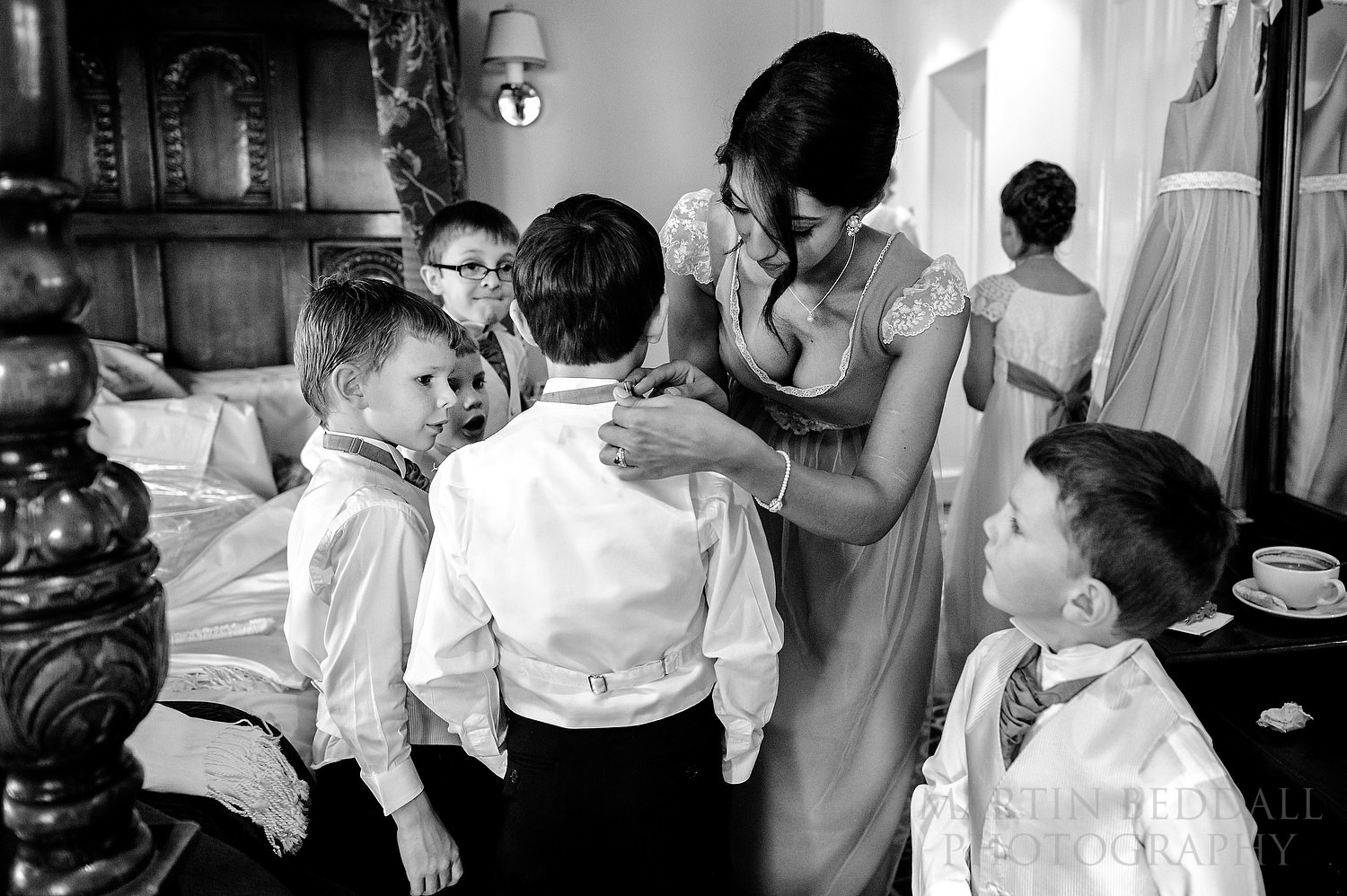 Bridesmaid helps dress a pageboy