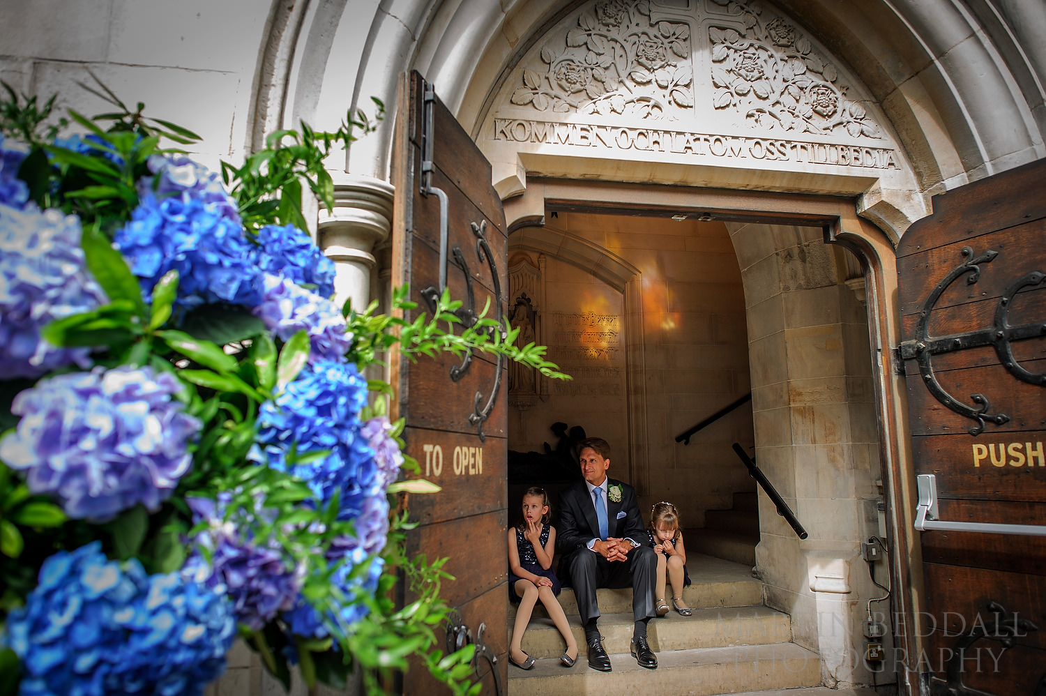 Groom waits on the steps of the Swedish church in London
