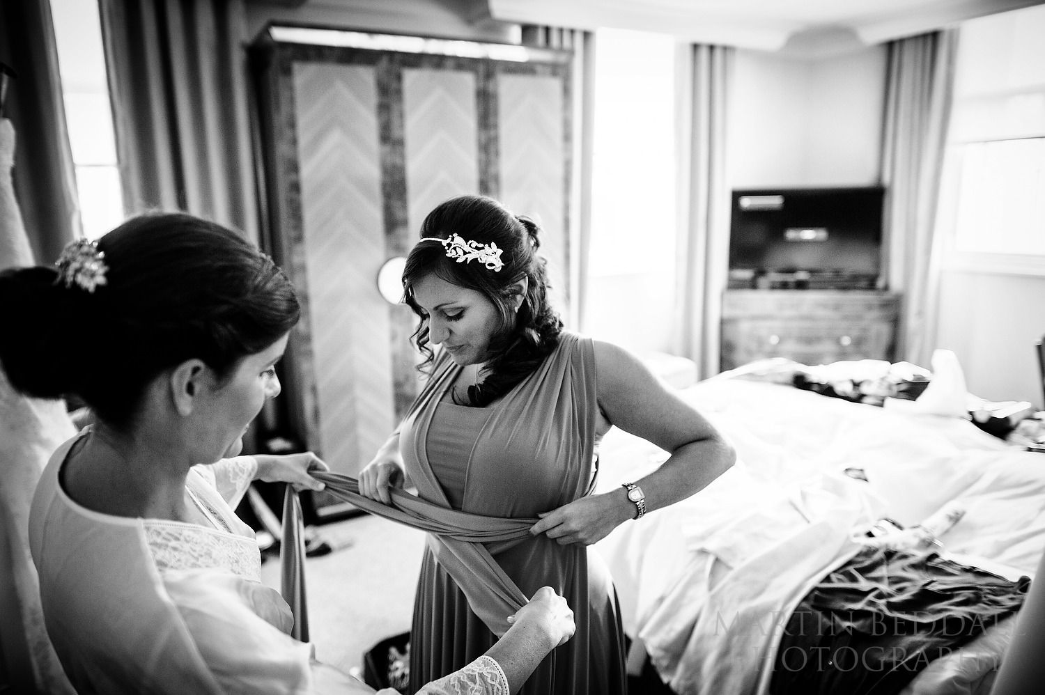 Bride helps a bridesmaid with her dress