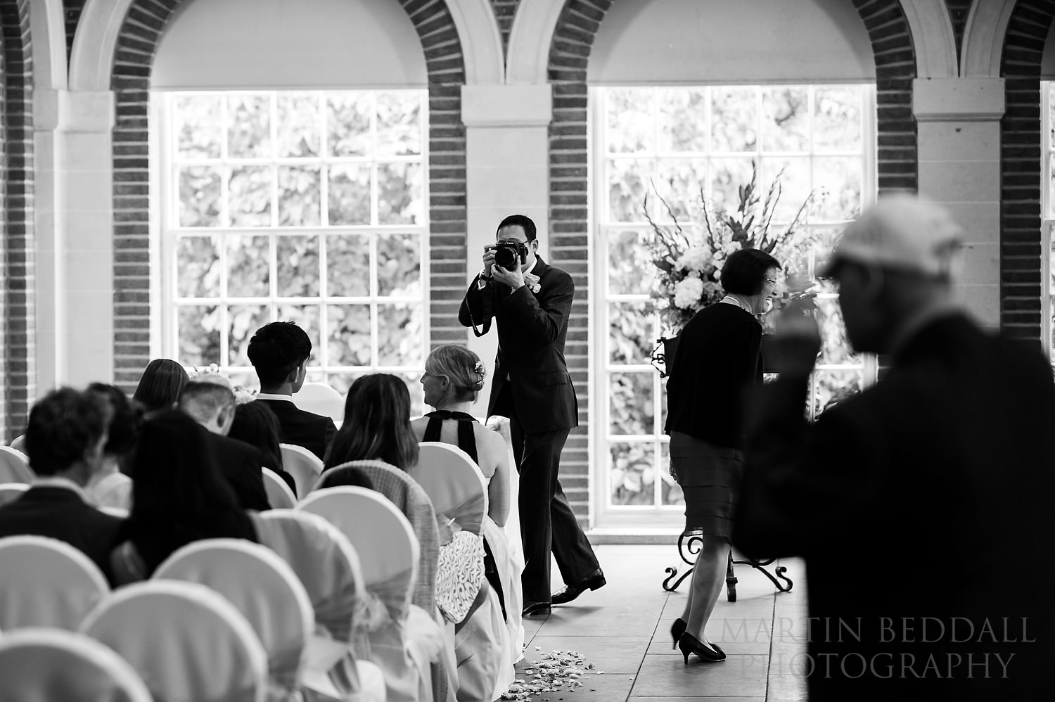 Groom with his own camera in the ceremony room at Great Fosters