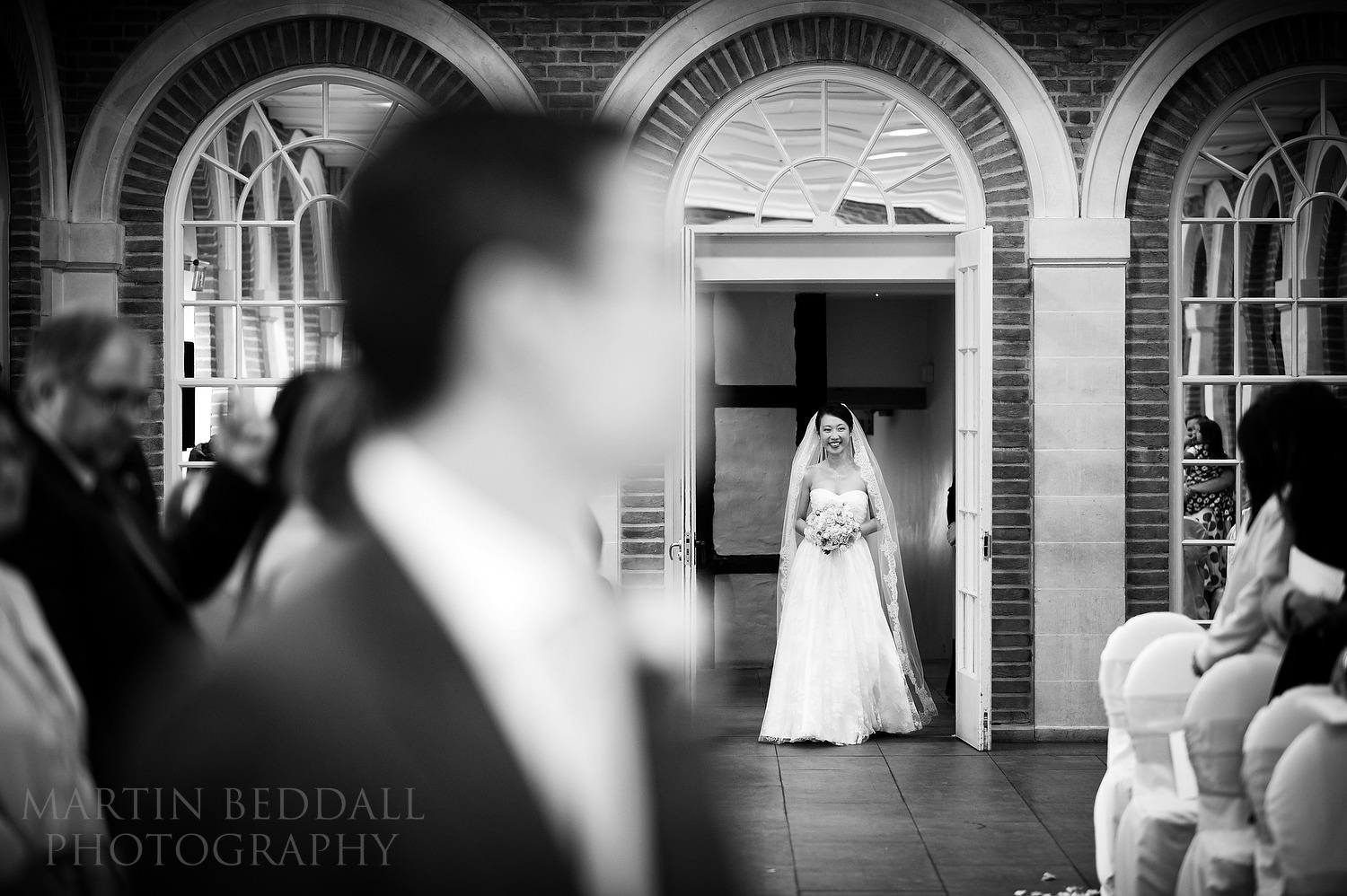 Bride enters the ceremony room at Great Fosters