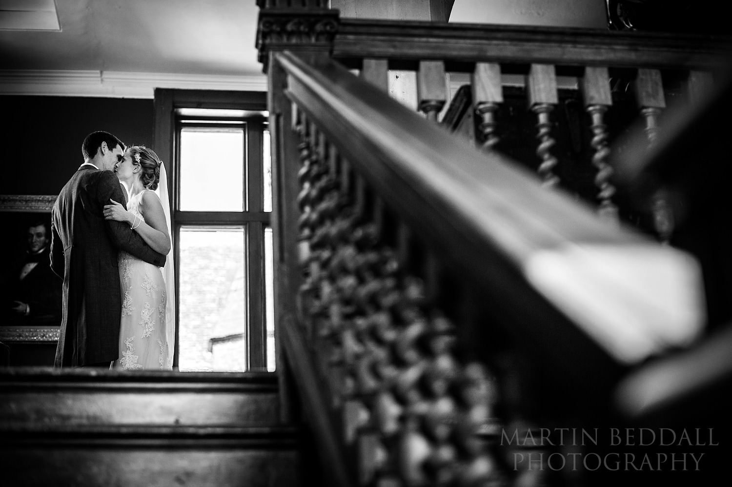 Bride and groom kiss at the top of the stairs