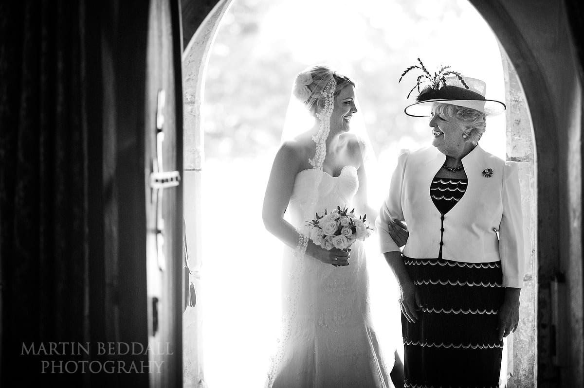 Bride and her mother in the dooorway of Buxted church