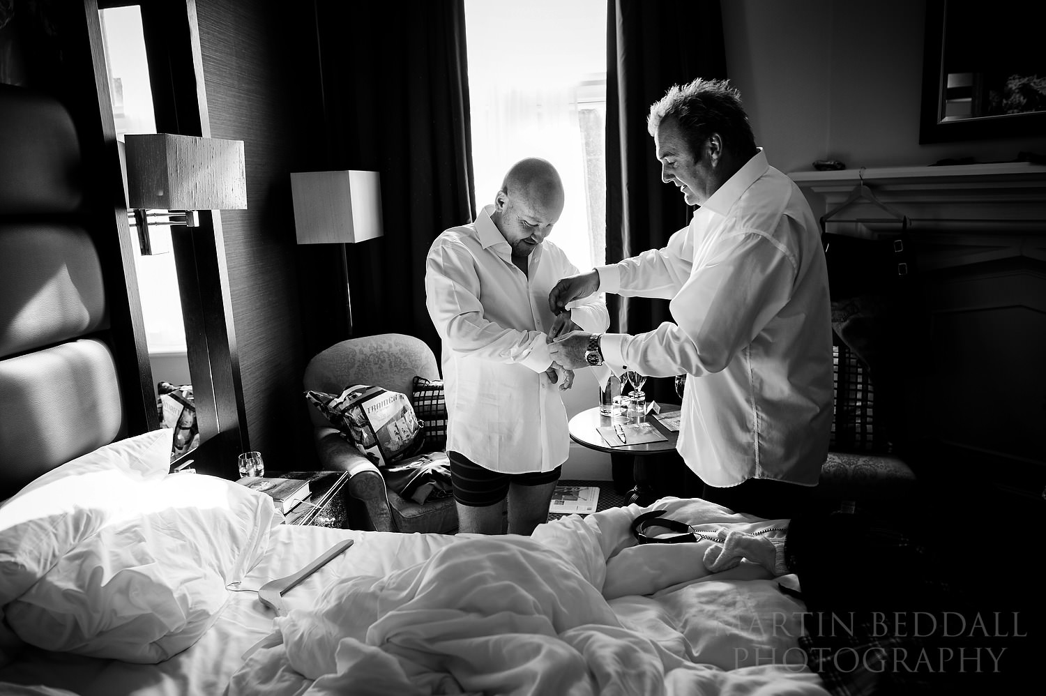 Best man helping with groom's cufflinks