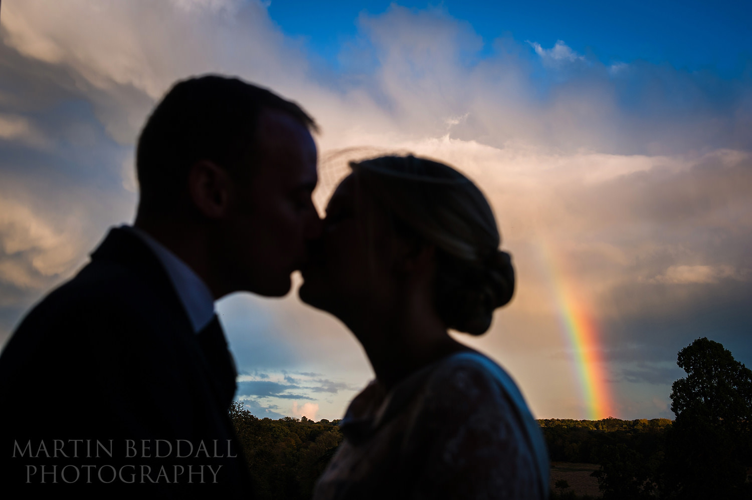 Couple portrait kiss rainbow at Buxted Park wedding