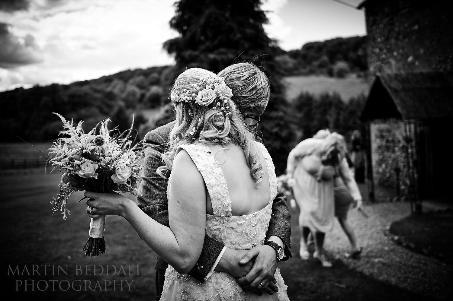 Couple embrace outside the chapel at the Lost Village of Dode wedding