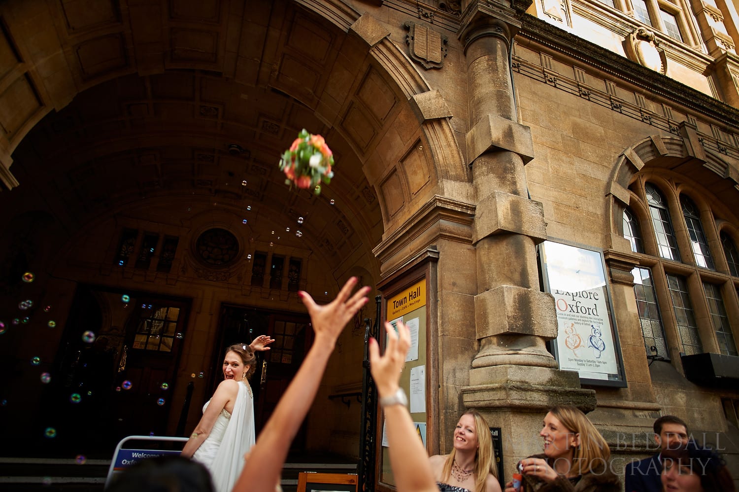 Bride throws the wedding bouquet outside Oxford Town Hall