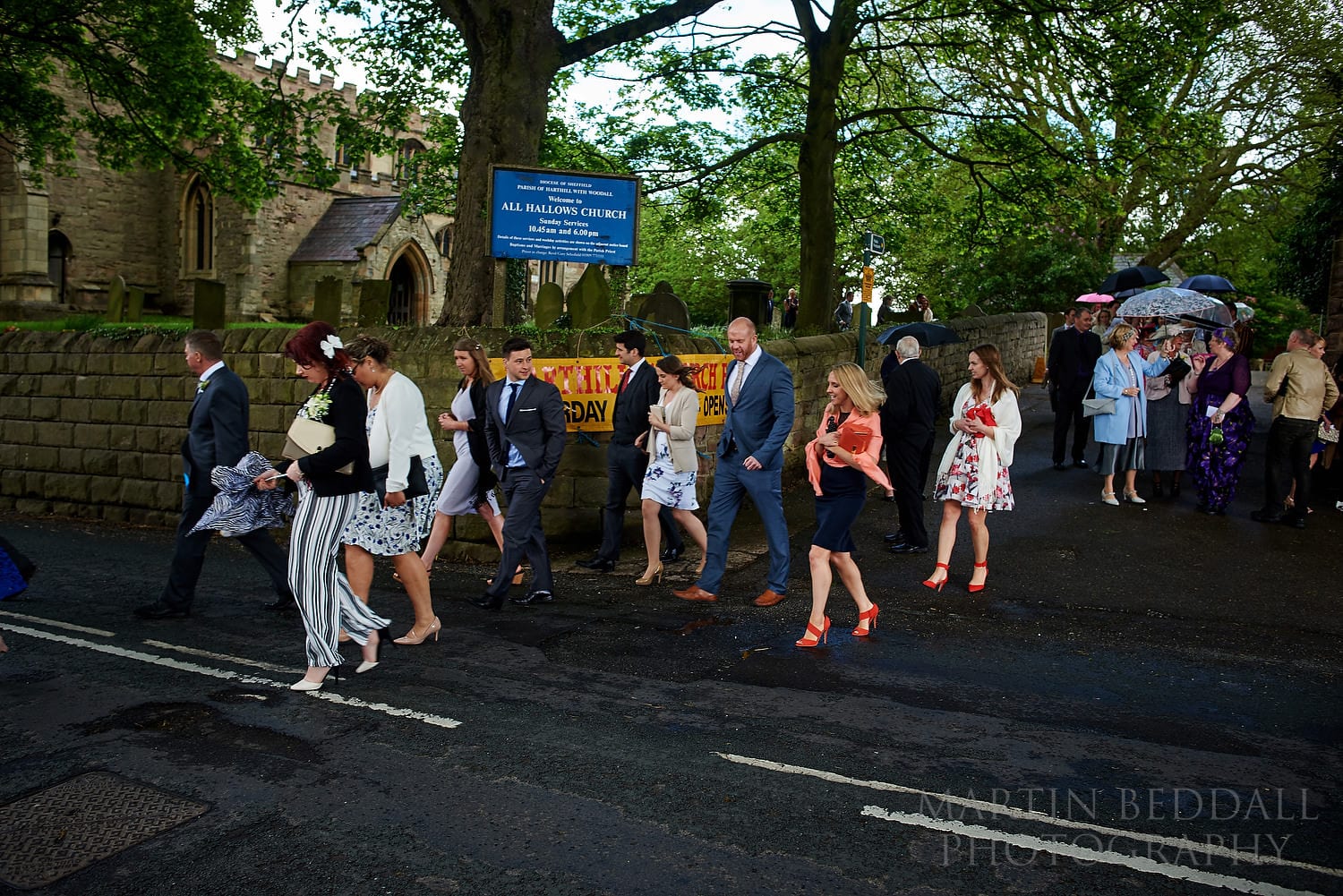 Wedding guests head across the road from the church to the wedding reception