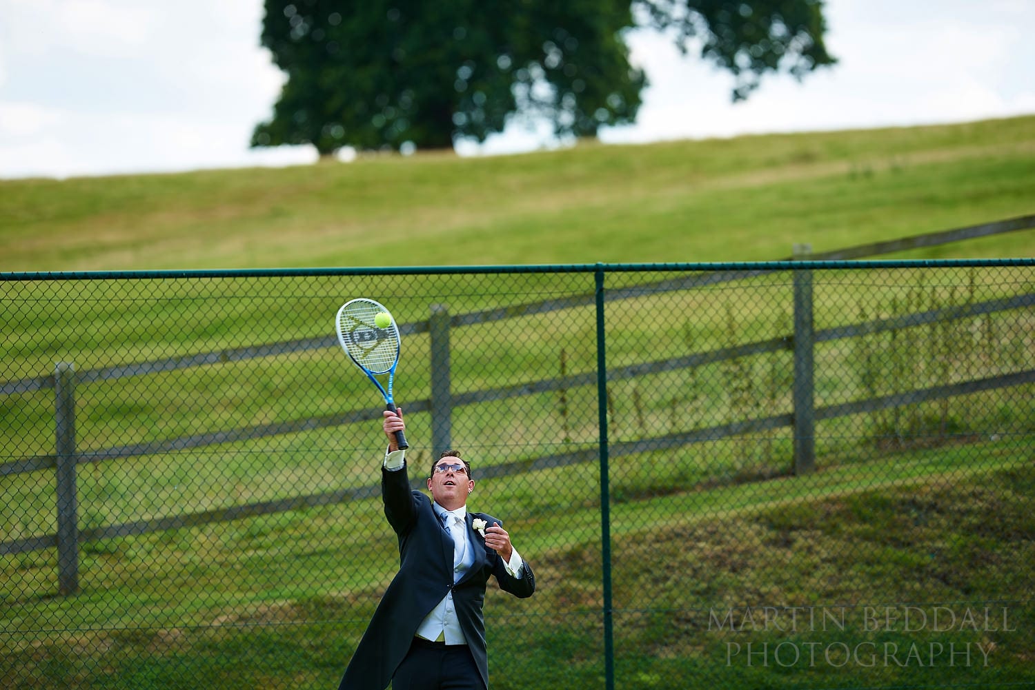 Playing tennis in a wedding suit