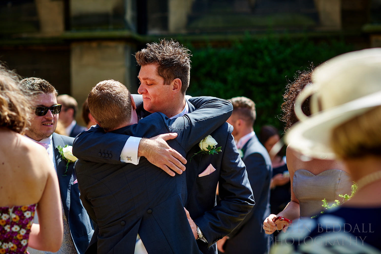 Friend hugs the groom