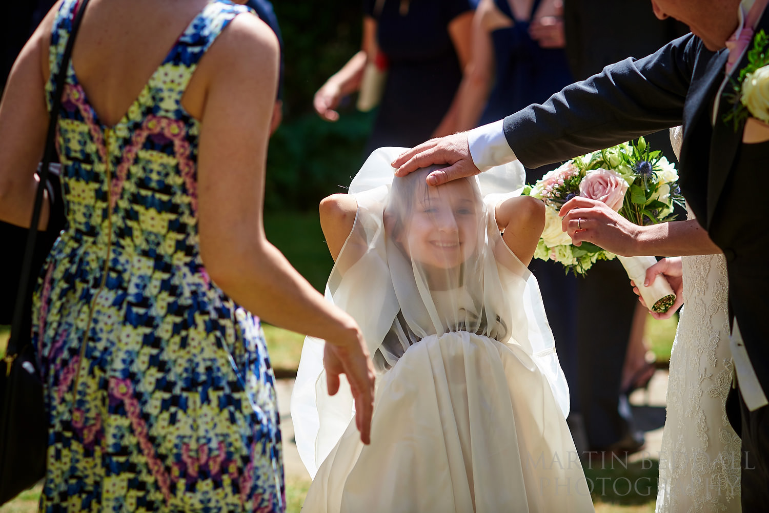Flower girl playing with the veil