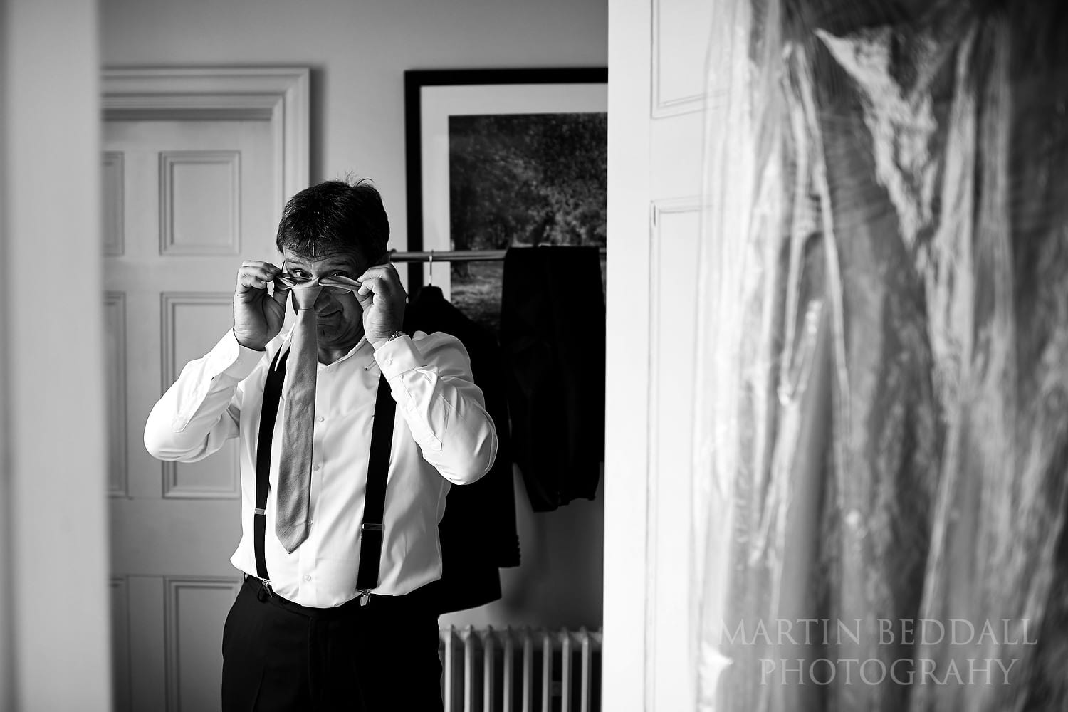 Bride's father pulls on his tie