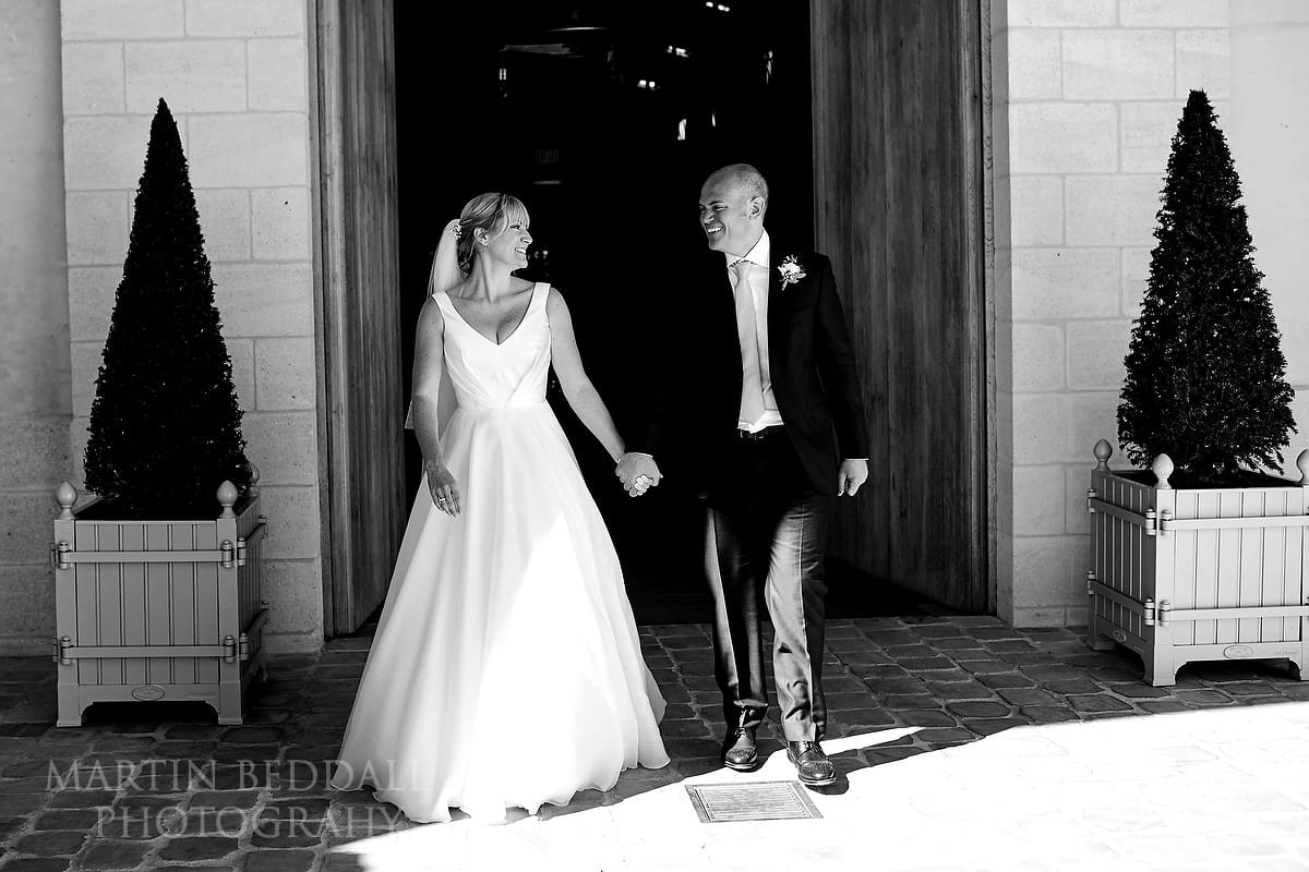 Bride and groom walk out into the sunshine at Château Soutard
