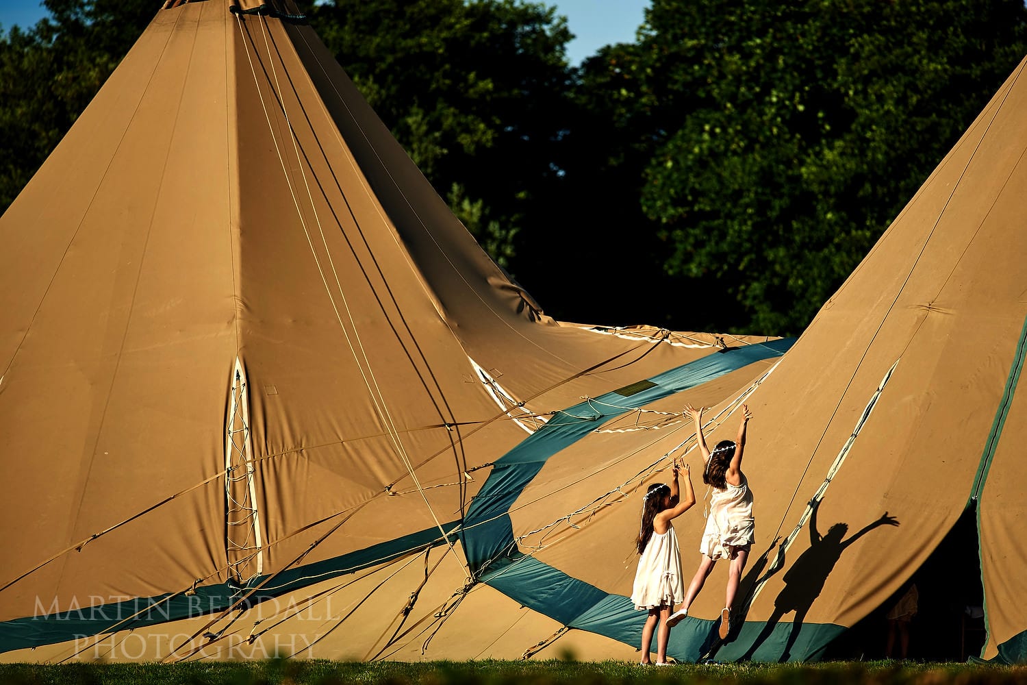Flower girls look at their shadows at Chafford Park wedding