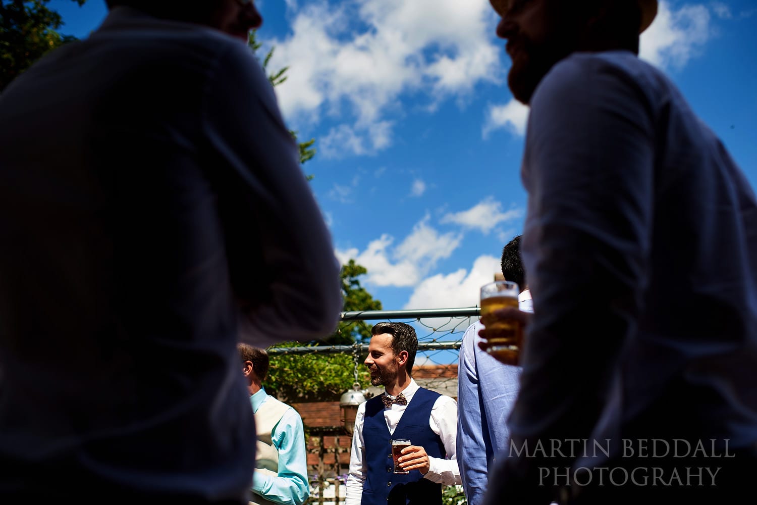 Groom has a pint in a pub garden