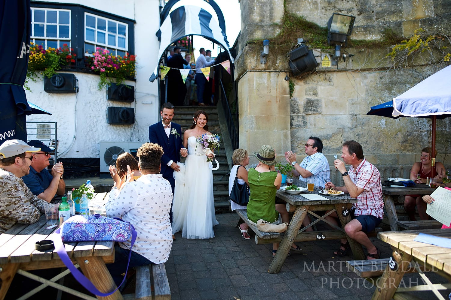 Pub customers applaud the bride and groom as they head to their boat