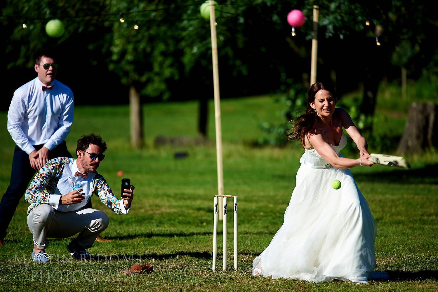 Bride plays cricket in her wedding dress at Festival style wedding