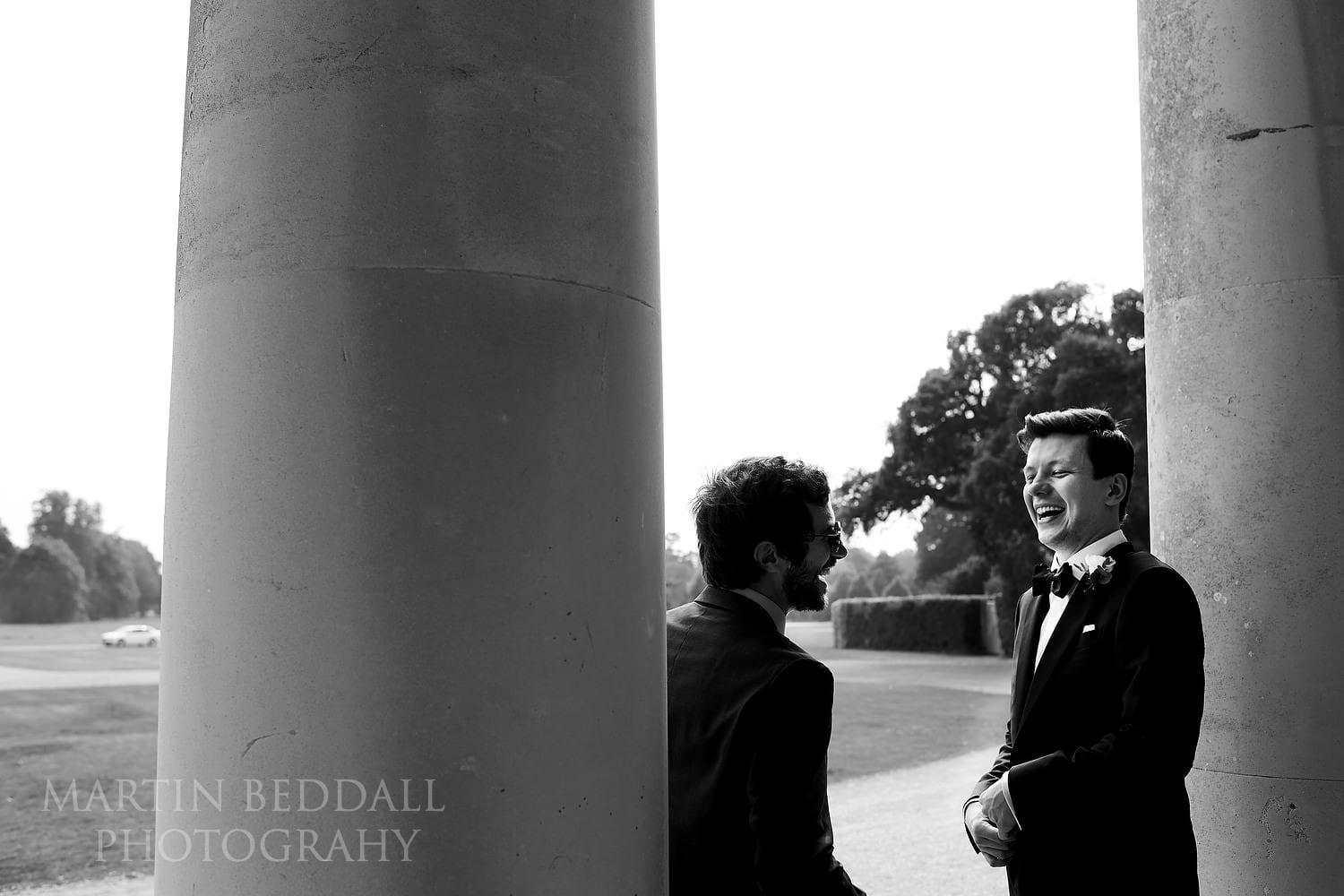 Groom laughing on the steps of Goodwood House 