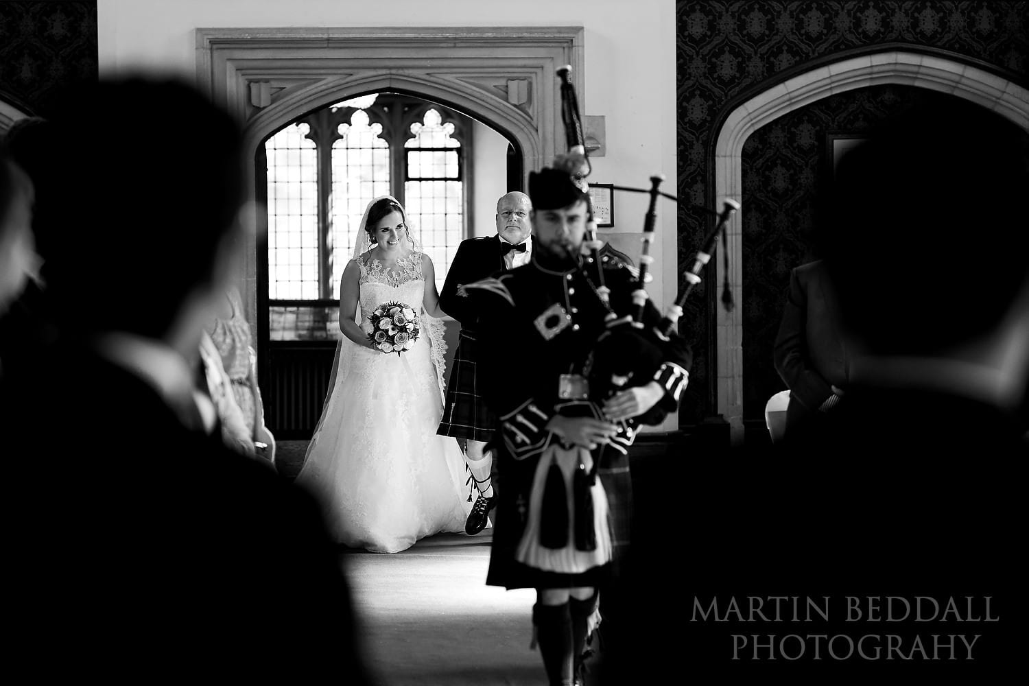 Piper leads in the bride and her father at Hanbury Manor