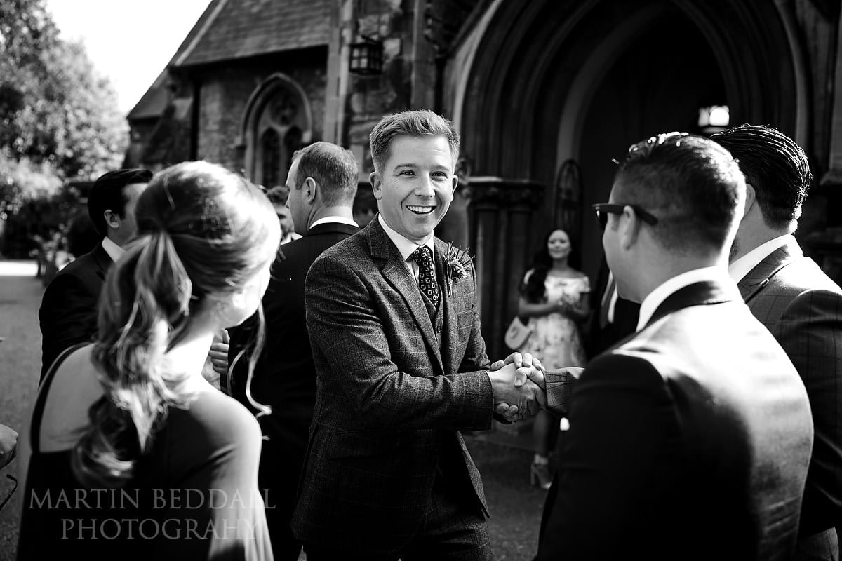 Groom greeting guests outside the church