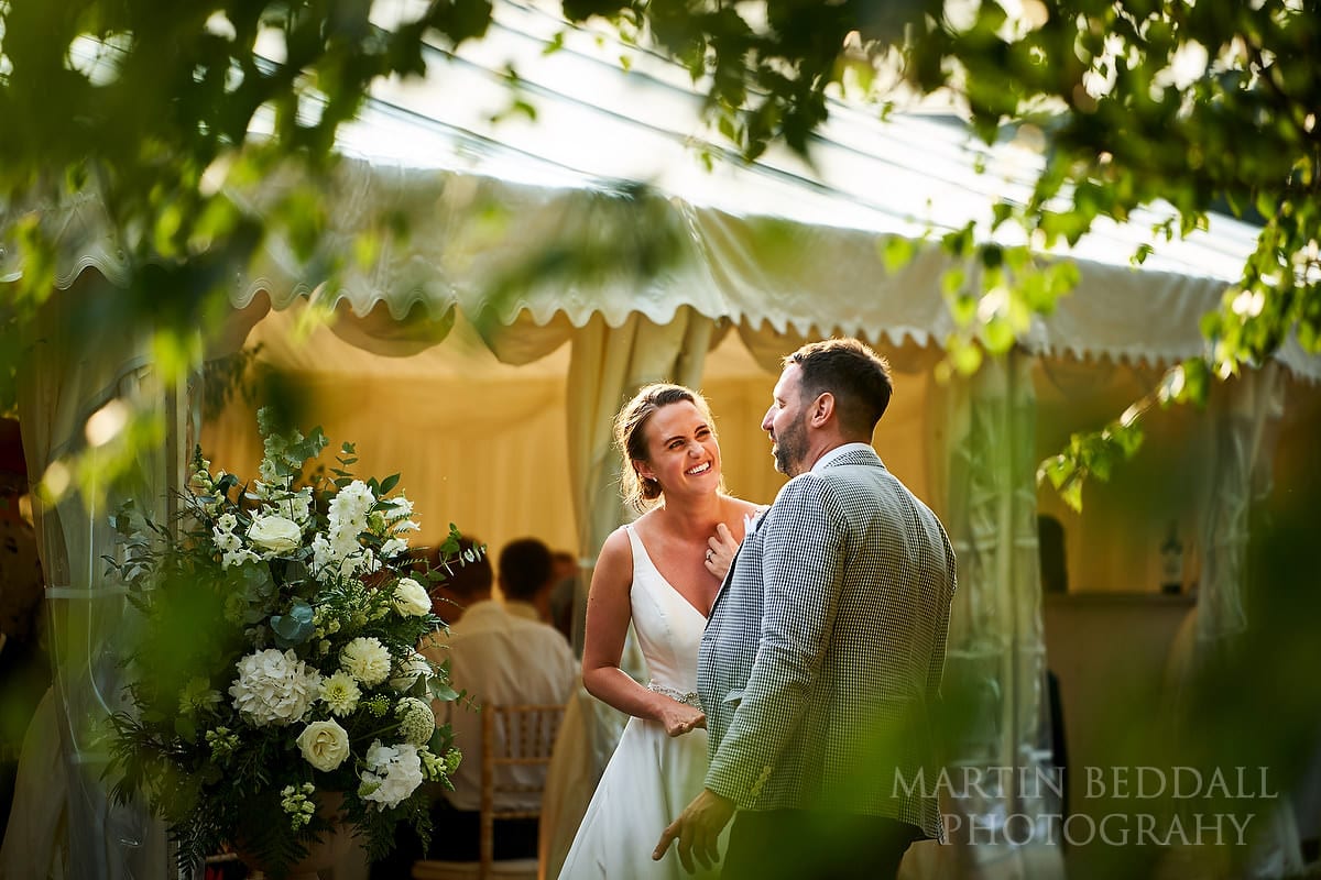 Bride laughing with a guest at Marquee in the garden wedding