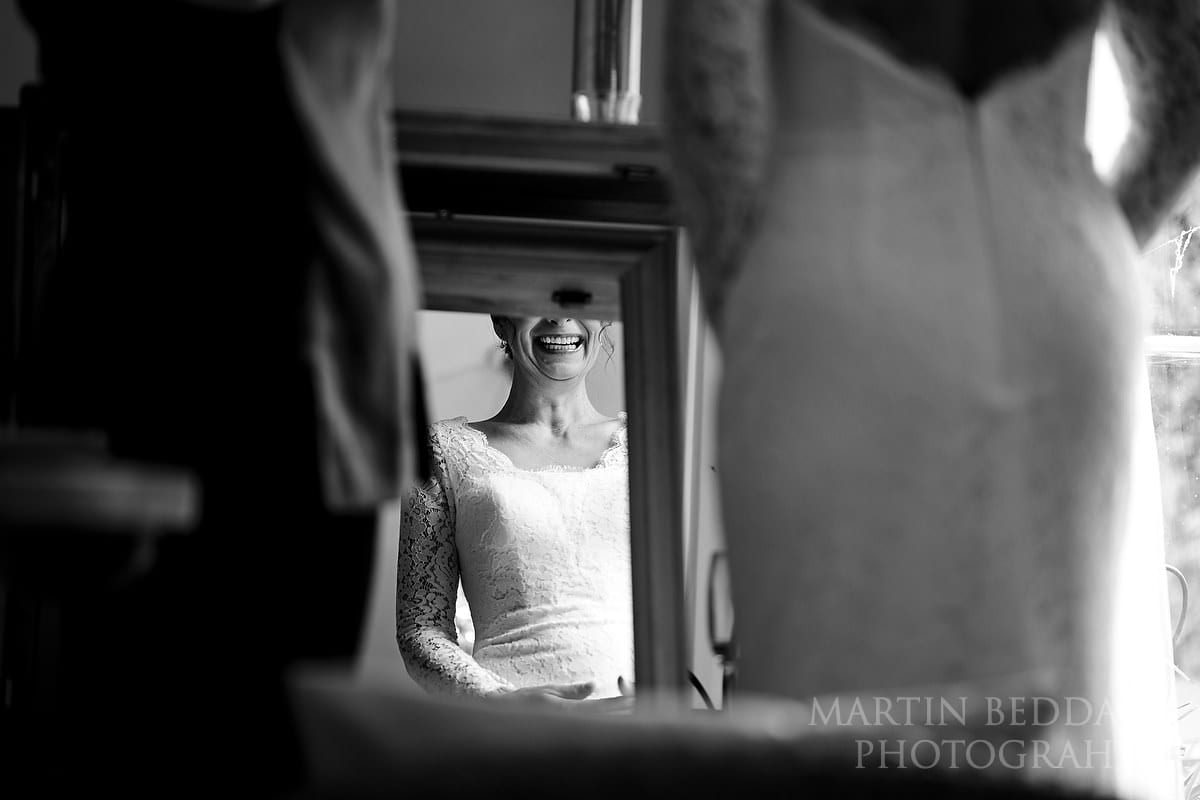 Bride smiling at herself in the mirror