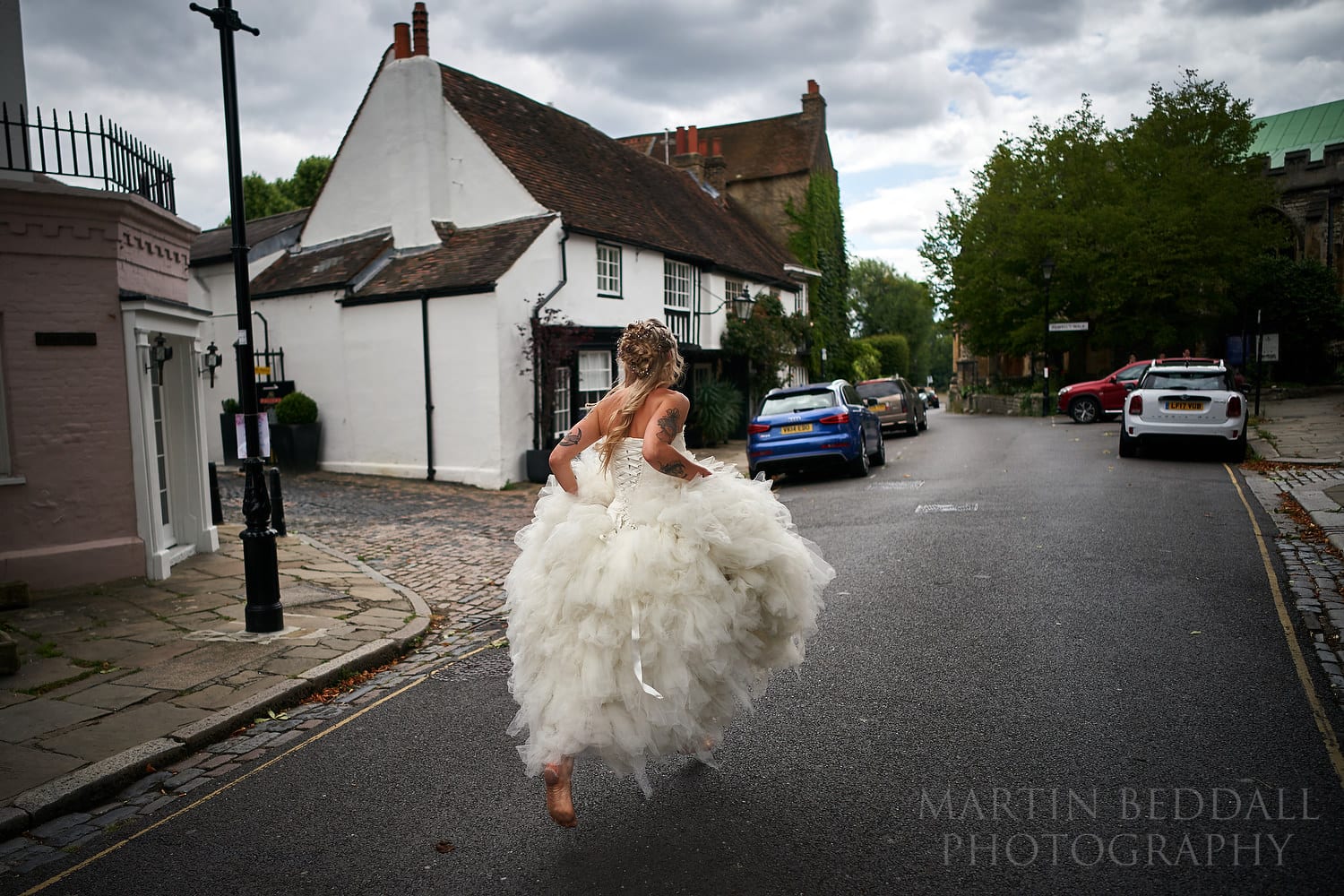 Barefoot bride running to the church in Chiswick