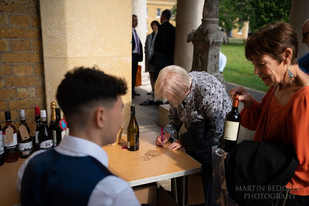 Guests bring bottles of wine for the wedding reception