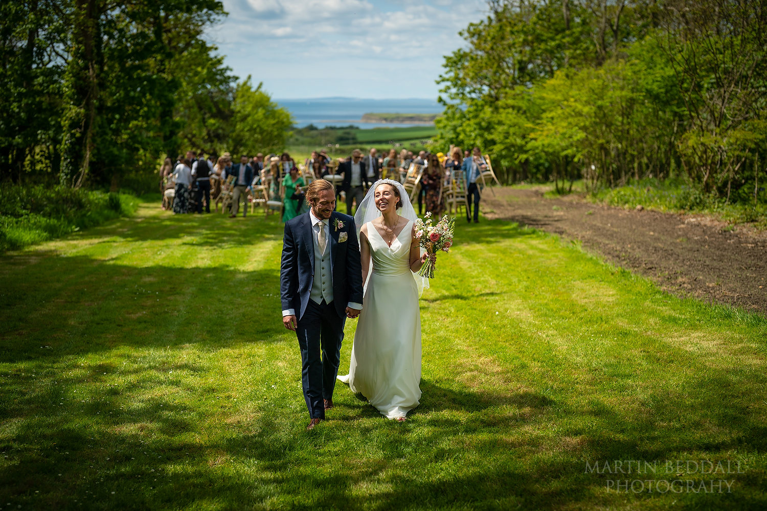 Bride and groom lead the guests to the wedding reception at Smedmore House