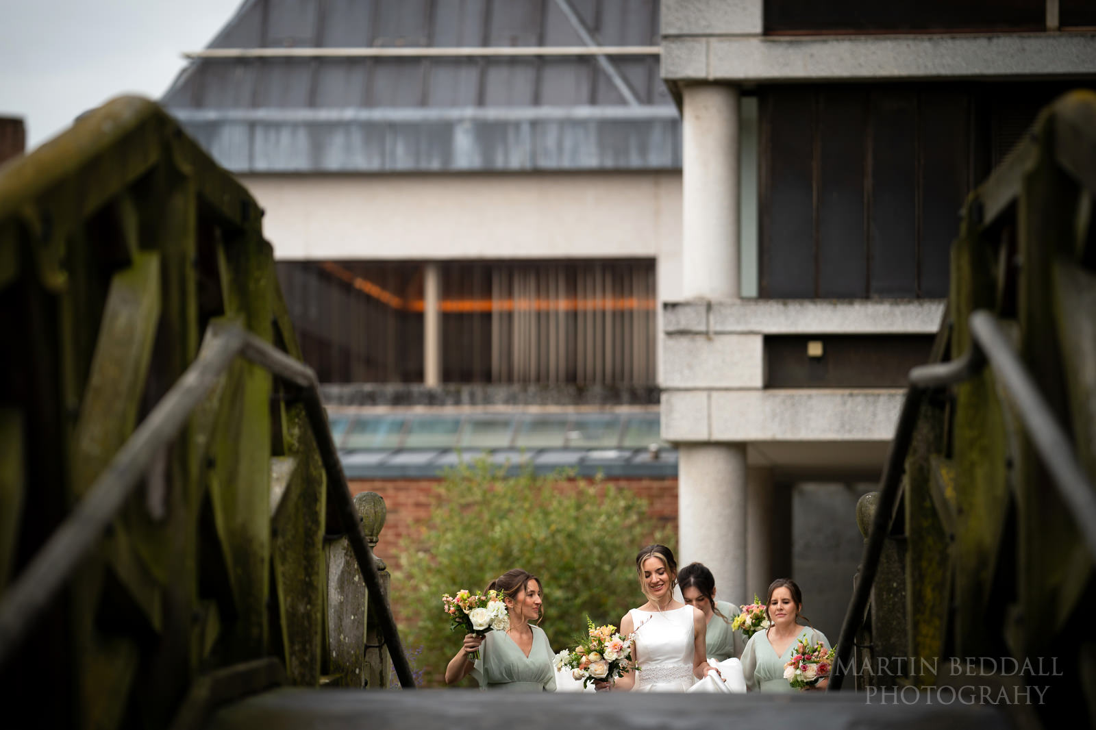 Bridal party walks over the Mathematical bridge in Cambridge