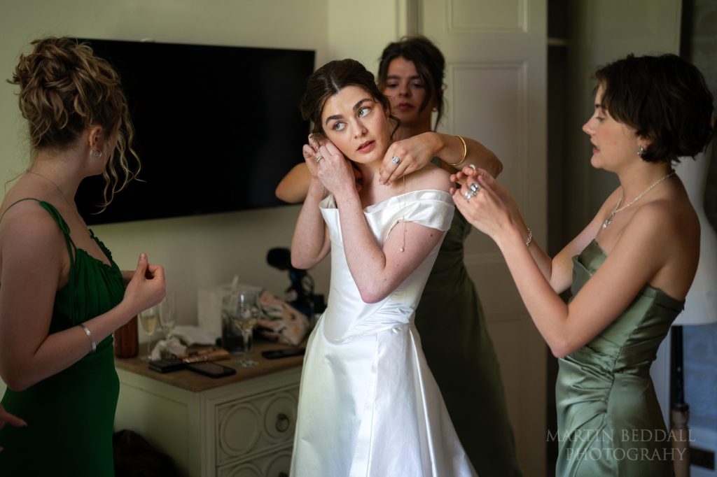 Bridesmaids dress the bride at West Sussex wedding