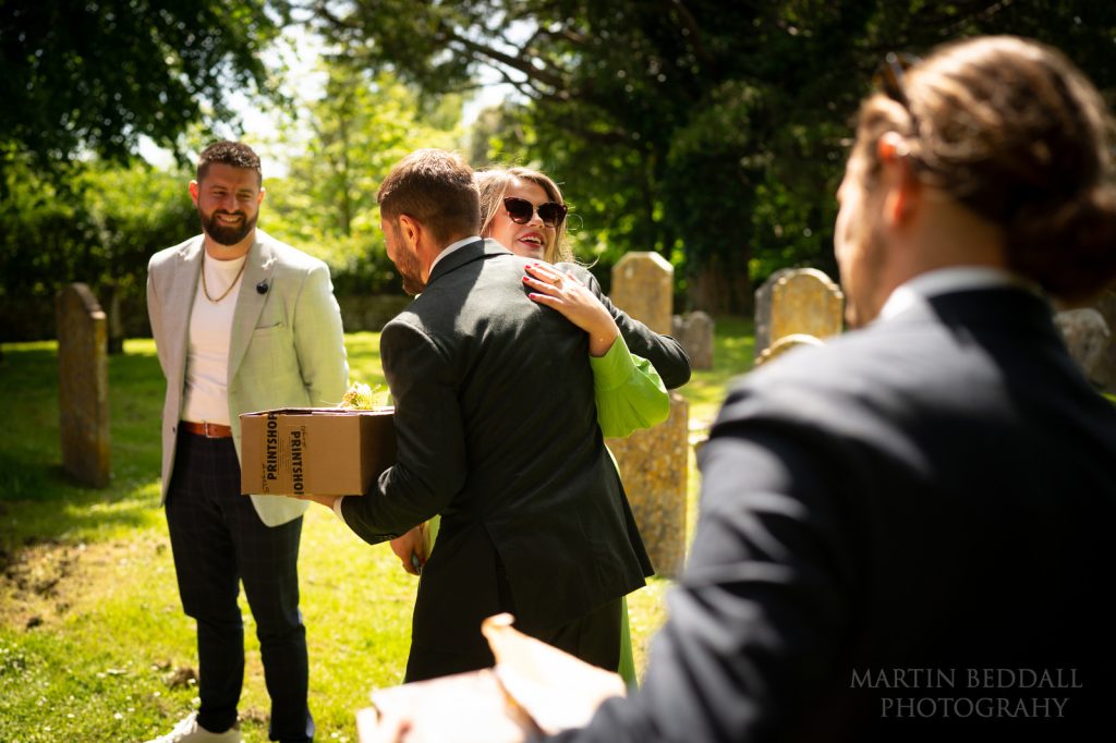 Groom greeting wedding guests in the sunshine