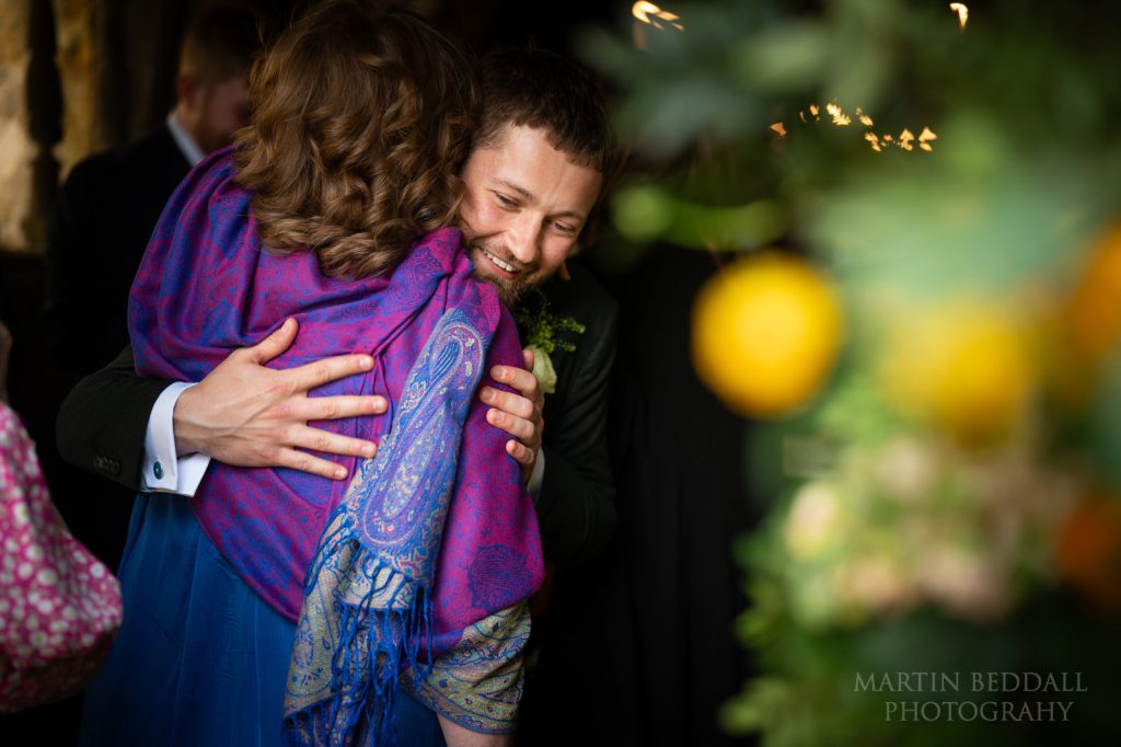 Groom hugs a wedding guest