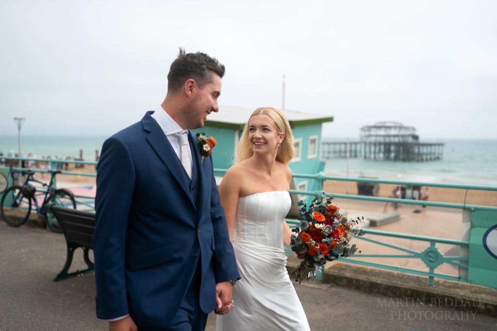 Bride and groom walk to the bandstand on Brighton seafront