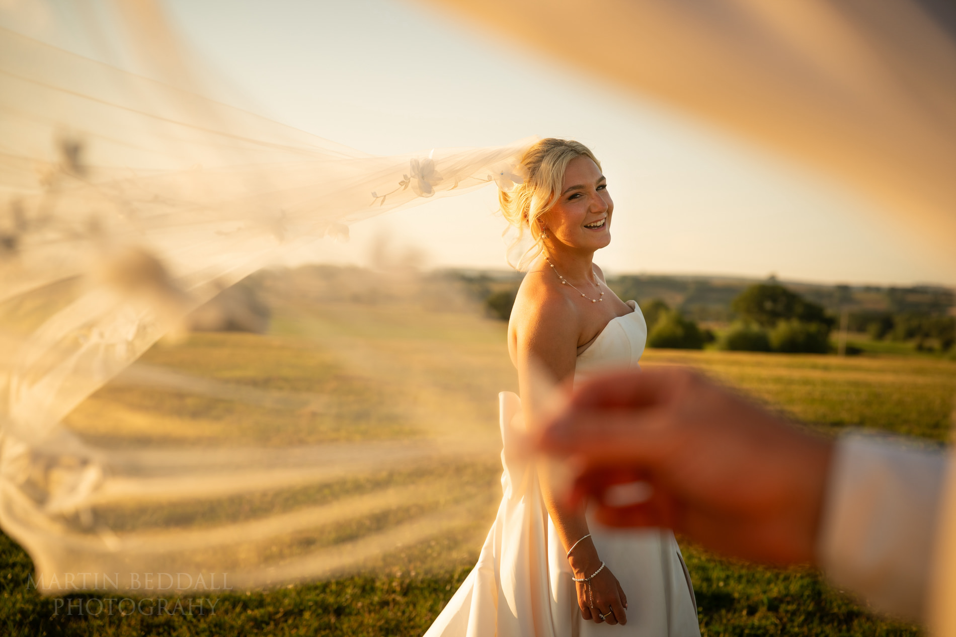 Groom plays with the bride's veil