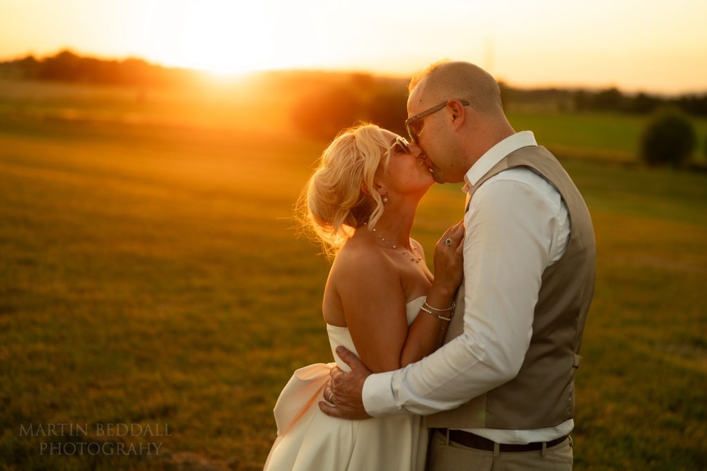 Sunset kiss at Glastonbury wedding