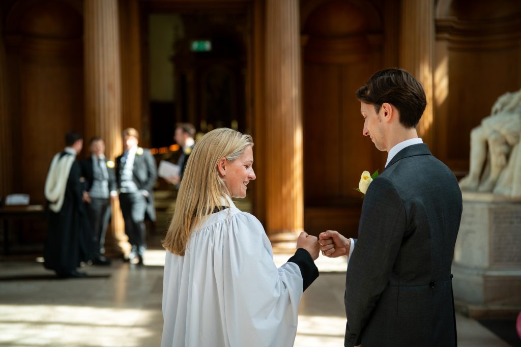 Groom fist pump with the chaplain